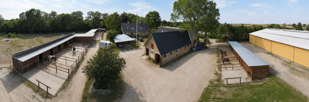 Luftfoto af Grangaardens stalde, paddocks og ridefaciliteter