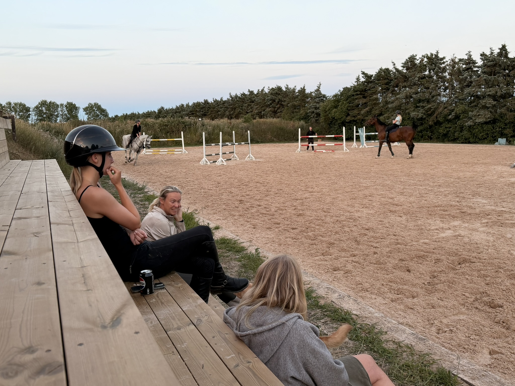Ryttere følger træning fra siden af Grangaardens udendørsbane