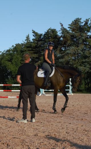 Hest og rytter undervises i spring på udendørs ridebanen på Grangaarden i Dragør